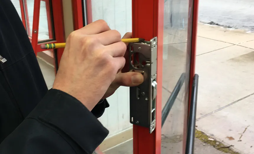 Locksmith securing commercial storefront door with advanced lock system