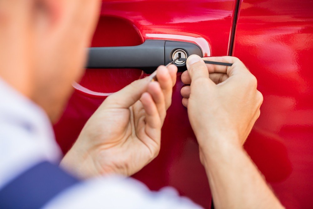 Automotive locksmith unlocking and repairing a car door lock