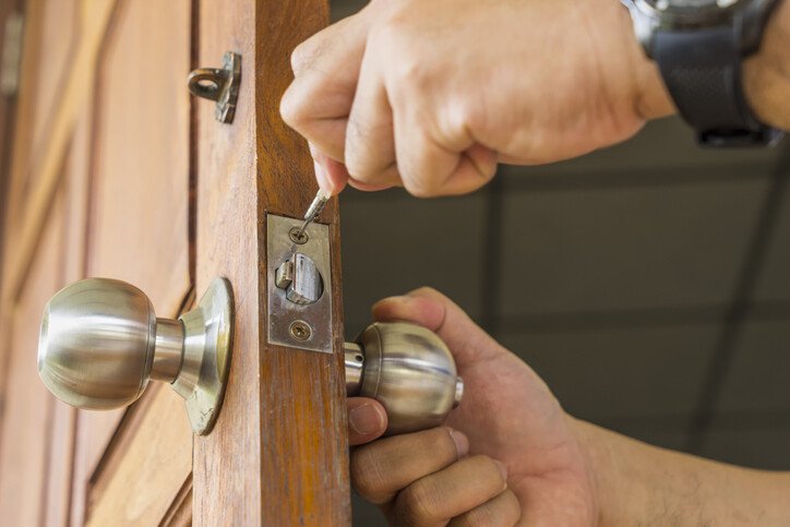 Professional locksmith working carefully on a door lock in Winston-Salem