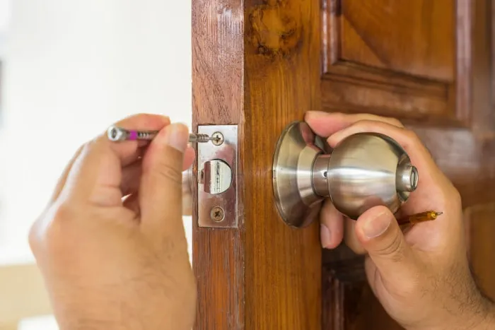 Home locksmith installing new deadbolt lock to improve family security