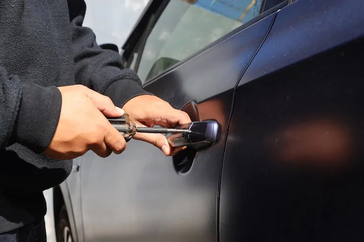 Automotive locksmith unlocking a car door during emergency lockout