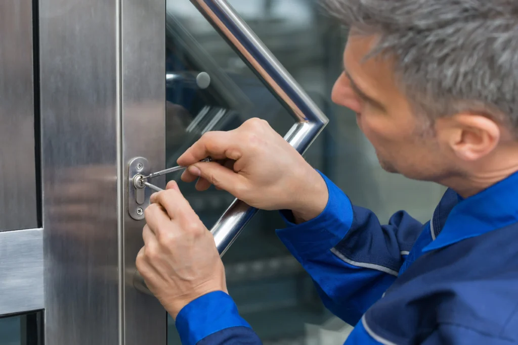 Locksmith installing and repairing a commercial door lock for business security